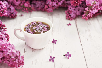 Obraz na płótnie Canvas Good morning concept. Cozy morning.Happy birthday greeting card. Hello spring and summer. Greeting card for Women's Day and Mother's Day. Spring season, copy space. Cup and lilac flowers.