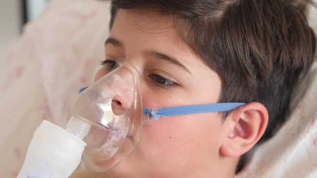 sick child in an oxygen mask in bed