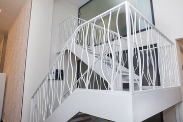 Two-storey iron white stairs for office . Interior of a modern living room with a staircase. Home...