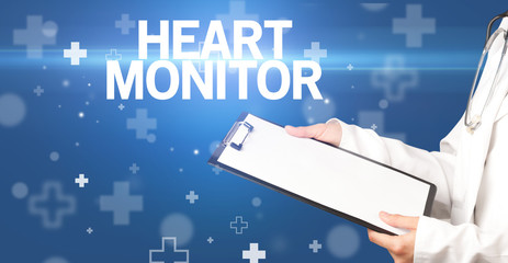 doctor writes notes on the clipboard with HEART MONITOR inscription, first aid concept
