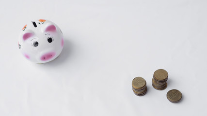 Piggy bank and stack of coins, saving money in white background. saving money is an investment for the future. Banking investment.