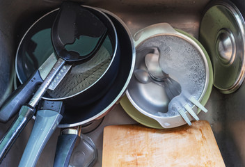 Close-up unwashed kitchenware in kitchen sink