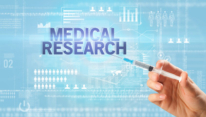 Close-up view of doctor's hand in a white glove holding syringe with MEDICAL RESEARCH inscription, healthcare and medical concept