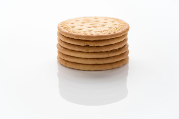 pile of round cookies on a white surface, illuminated with a circle of light