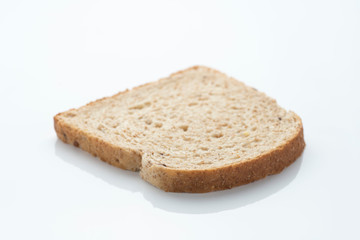 slice of sliced ​​bread with cereals and seeds, on a white surface with reflection