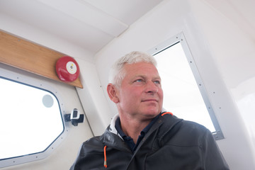 Naklejka na ściany i meble Portrait of a captain in his boat's cabin