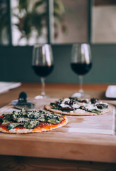 Dinner Homemade Pizza with Red Wine in Glasses on Wooden Table