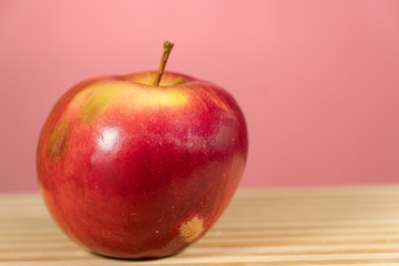 Red apple with leaf on wooden table