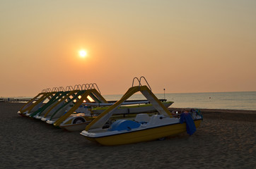 Beautiful coastline of the Adriatic Sea. Sunset on the beach of Lido di Jesolo. Piers in the sea