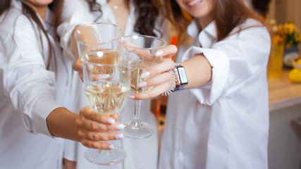 There's toast. A group of female friends in white shirts clink glasses with champagne.