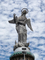 The statue Virgin of Quito with some clouds