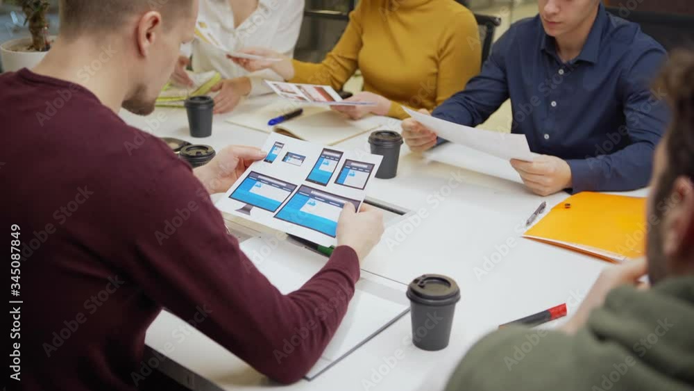 Wall mural female marketing manager giving printouts with application interface templates for different devices