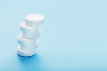 Tower of Medicinal tablets on a blue background, isolated.