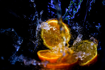 sliced ​​orange in water with splashes