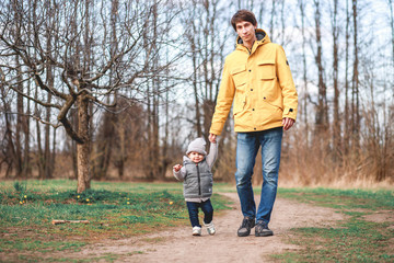 Fototapeta premium A little boy walks in the woods with his father