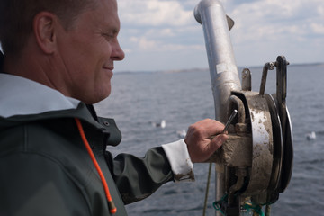 fisherman using equipment on boat 