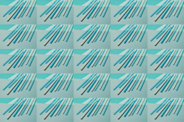 Collage of white and blue plastic tubes on the turquoise and light blue background. Plastics in our everyday life. Conceptual art pattern. Geometrical lines. Selective focus, top view