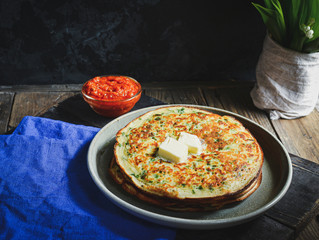Thin pancakes with herbs. Salty Pancakes with green onions. Wood background. Vintage background. Delicious food for a bite to eat. Free space for text. Blue linen napkin