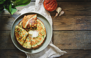 Thin pancakes with herbs. Salty Pancakes with green onions. Wood background. Vintage background. Delicious food for a bite to eat. Free space for text. Top view