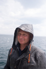 Portrait of a captain in rain jacket on his boat  © viktor holm