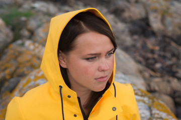 portrait of beautiful woman in yellow rain jacket in archipelago