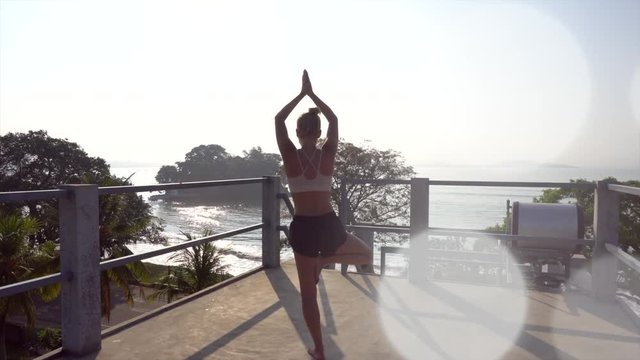 Woman doing yoga tree pose on the roof top