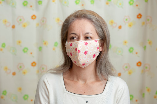 Portrait Of Middle Aged Mixed Race Woman Wearing (DIY) Homemade Fabric Face Mask For Protection Against Coronavirus (COVID-19) And Other Infectious Diseases. Looking To The Side. 