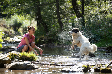 Woman and her dog in the summer river.