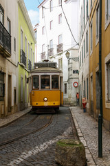 Fototapeta na wymiar Cable car in a narrow street in Lisbon
