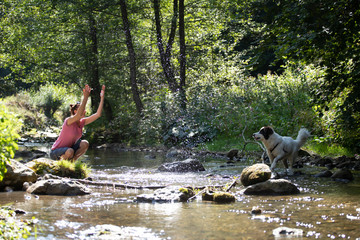 Fototapeta na wymiar Woman and her dog in the summer river.