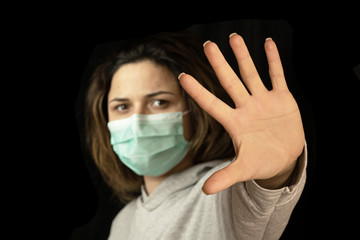 Stop the virus and epidemic diseases. Healthy woman in blue medical protective mask showing gesture stop.