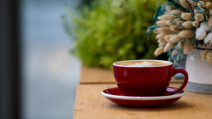 a Cup of coffee is on the table with flowers