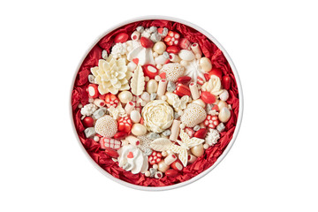 Round box filled with handmade white chocolate candies isolated on white background
