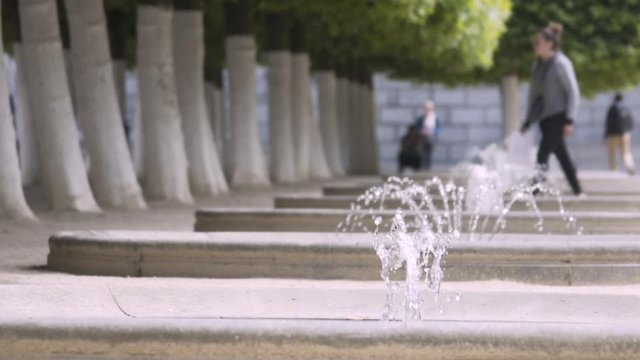 Close up of fountains with a girl walking in the background at a park Kunstberg Brussels Belgium. 100 fps slow motion footage slowed down to 25 fps.