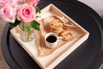 Low square carton box with cup of coffee and crispy cookies on paper