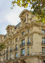 Parisian apartment building in the old architectural style. The building has wrought-iron balconies. France. Autumn.