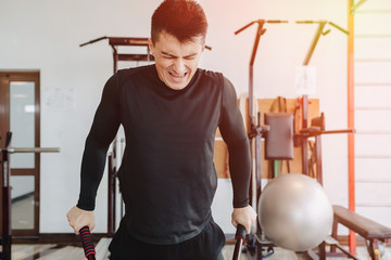 sports guy squeezes on bars, exercises on pectoral muscles. healthy lifestyle.