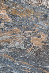 strukturierter, bröckeliger, grauer Fels mit Muster und Mineralienlinien