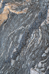 strukturierter, bröckeliger, grauer Fels mit Muster und Mineralienlinien