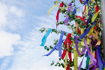 May tree decorated with colorful ribbons against sky. Young couples traditional gift on May first. ...