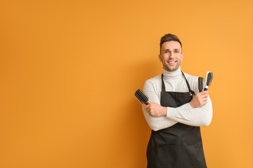 Male hairdresser on color background