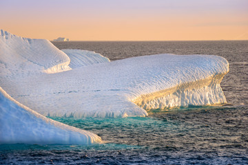 Polarsommer - Beeindruckende Landschaft während des Polarsommers mit einem Eisberg mit schöner Lichtstimmung in der Nacht.