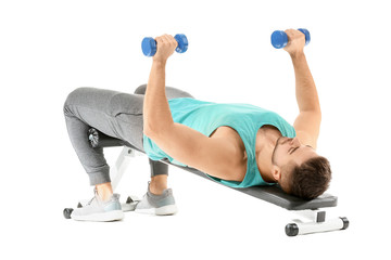 Sporty young man training with dumbbells on white background