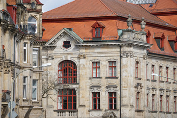 Obraz premium Fassade eines klassischen Gebäudes mit Sandstein, roten Fenstern mit Bogen und roten Dachziegeln. Amtsgericht Bayreuth von Hinten. Bayern, Deutschland.