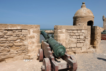 Fototapeta na wymiar Antique green copper cannon facing Atlantic ocean on fort wall in Essaouira, Morocco,
