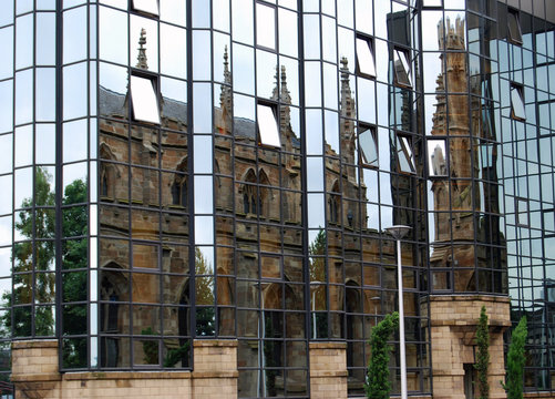old church reflected in a modern glass building