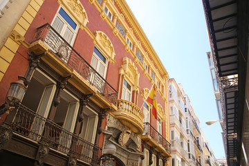 Obraz premium Looking up at the beutiful buildings & architecture lining La Calle Mayor, which is the heart of Cartagena. Cartagena, Murcia, Spain.