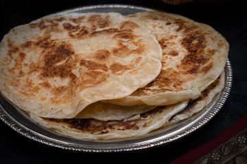 Indian layered flaky bread paratha on silver plate
