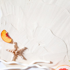 Beach vacation. Starfish, and a white tree branch and juicy fruits lie on white fine sand. Desktop...