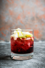 Old fashioned cocktail with blackberry liqueur and apple slices on rustic background. Selective focus. Shallow depth of field.